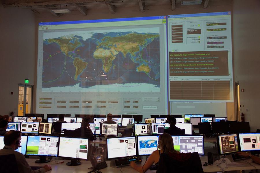 A team monitoring a large world tracking map in an operations centre