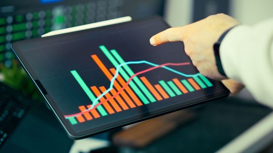 A hand pointing at forecasting trend charts on a tablet