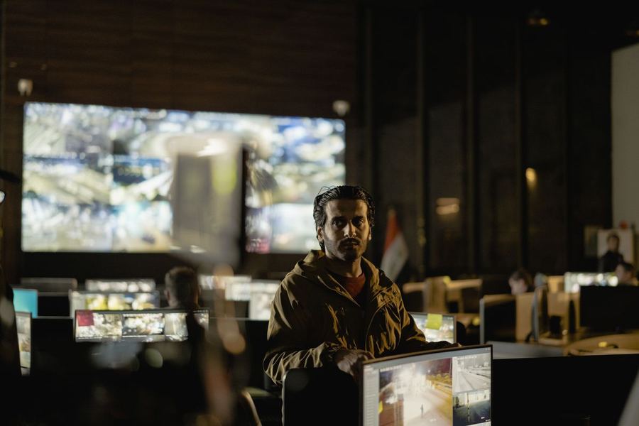 An analyst monitoring a wall of security camera feeds